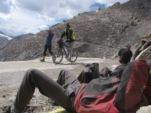 Samantha Gash on her way to Leh from Khardung La; a member of her team keeps company on a bicycle. Watching on are BRO workers enjoying a break (Photo: Shyam G Menon)